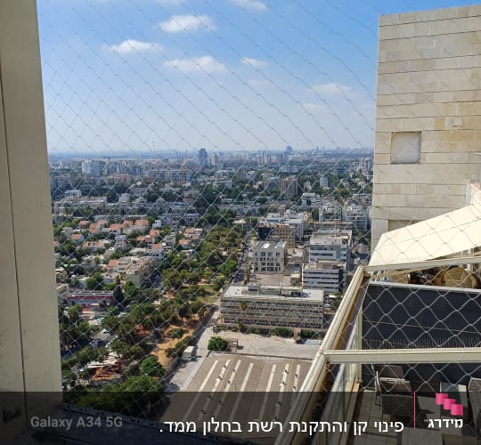 נוף עירוני עם רשת הגנה על מרפסת בניין